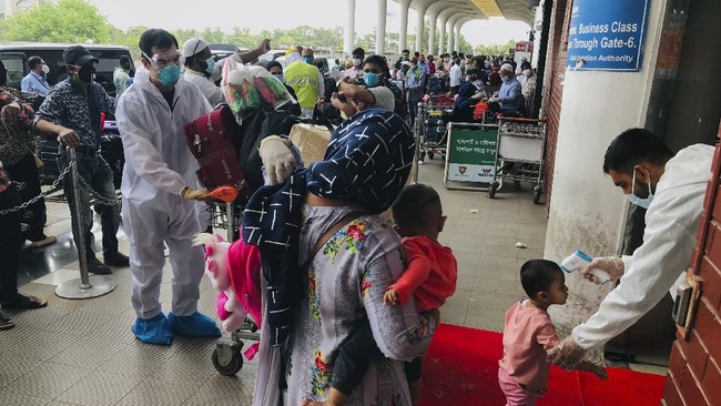 British and American nationals who were stranded in Bangladesh arrive to board repatriation flights at the Hazrat Shahjalal International Airport as the country continues to be in lock down to prevent the spread of the new coronavirus in Dhaka, Bangladesh, Tuesday, April 21, 2020. Bangladesh, a nation of 160 million people, is struggling to keep its number of infections in check as community transmission of the virus has invaded the common people across the country. (AP Photo/Al-emrun Garjon)