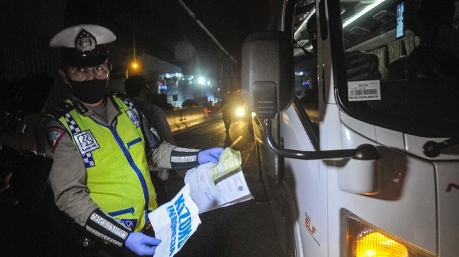 Polisi memeriksa surat ijin sopir mobil travel yang membawa tiga orang TKI ( Tenaga Kerja Indonesia ) dari luar negeri di tol Jakarta-Cikampek, Cikarang, Kabupaten Bekasi, Jawa Barat, Sabtu (25/4/2020). Pada hari kedua penyekatan pemudik di jalan tol masih banyak kendaraan yang tidak mengatur jarak sosial  dan warga yang memaksaan untuk mudik. ANTARA FOTO/ Fakhri Hermansyah/pras.
