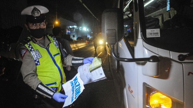 Polisi memeriksa surat ijin sopir mobil travel yang membawa tiga orang TKI ( Tenaga Kerja Indonesia ) dari luar negeri di tol Jakarta-Cikampek, Cikarang, Kabupaten Bekasi, Jawa Barat, Sabtu (25/4/2020). Pada hari kedua penyekatan pemudik di jalan tol masih banyak kendaraan yang tidak mengatur jarak sosial  dan warga yang memaksaan untuk mudik. ANTARA FOTO/ Fakhri Hermansyah/pras.