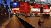 kosong dan sepi, cara las vegas bertahan hidup In this April 19, 2020, photo, a lone security guard watches over casinos shuttered due to the coronavirus outbreak in Las Vegas.