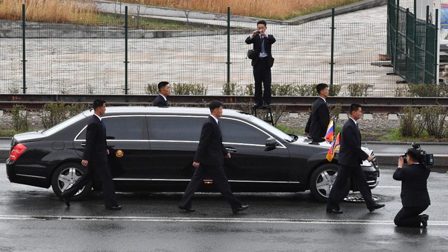 Bodyguards surround the car of North Korean leader Kim Jong Un as it drives away after a wreath-laying ceremony at a WWII memorial in the far-eastern Russian port of Vladivostok on April 26, 2019. (Photo by Yuri KADOBNOV / AFP)