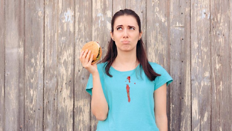 Ilustrasi wanita makan burger berantakan.
