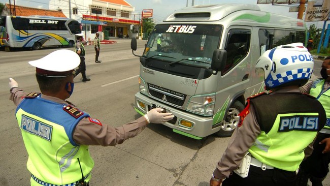 Petugas kepolisian memerintahkan mobil  travel untuk memutar kembali ke arah Jakarta saat penyekatan di jalur Pantura, Tegal, Jawa Tengah, Senin (27/4/2020). Penyekatan kendaraan pemudik oleh Polres Tegal Kota itu dilakukan menyusul adanya larangan mudik oleh Pemerintah guna mencegah penyebaran COVID-19. ANTARA FOTO/Oky Lukmansyah/hp.