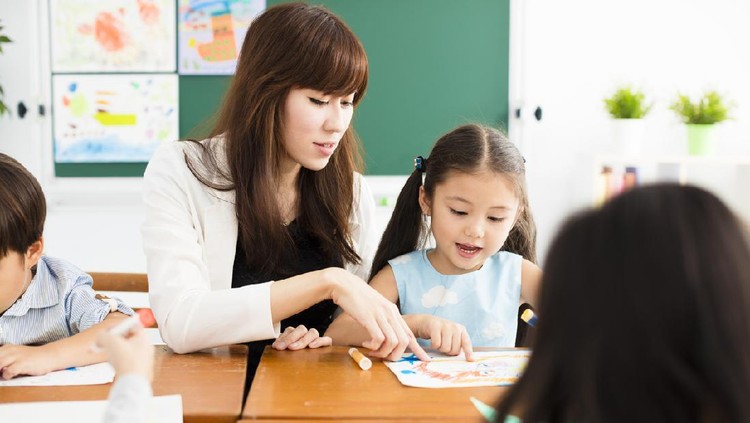 Teacher and kids in an elementary school lesson with tablets
