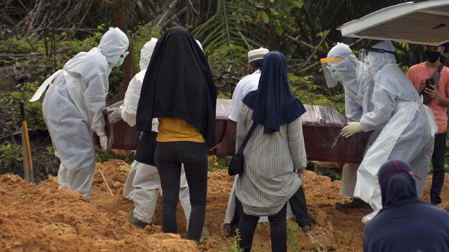 Sejumlah keluarga pasien memperhatikan tenaga medis dan penggali kubur yang mengenakan alat pelindung diri saat proses pemakaman keluarganya di Tempat Pemakaman Umum (TPU) Tengku Mahmud Palas di Kota Pekanbaru, Riau, Selasa (28/4/2020). Pemerintah Indonesia menyatakan hingga 28 April pukul 12.00 WIB, jumlah kematian akibat COVID-19 mencapai 773 orang dari 9.511 kasus terkonfirmasi positif, sedangkan yang sembuh ada 1.254 orang. ANTARA FOTO/FB Anggoro/hp.