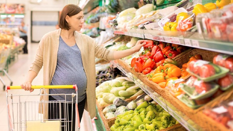 ibu hamil woman in a shop considering vegetables