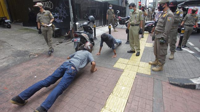 PENERTIBAN PSBB TIDAK PAKAI MASKER Petugas gabungan memberikan hukuman push up kepada warga yang tidak memakai masker saat razia Pembatasan Sosial Berskala Besar(PSBB) di Kawasan Jalan Fatmawati, Jakarta, Selasa (28/4/2020). Penertiban tersebut terkait pelaksanaan Pembatasan Sosial Berskala Besar(PSBB) di wilayah Jakarta dan memutus rantai penyebaran COVID 19. ANTARA FOTO/Reno Esnir/foc.