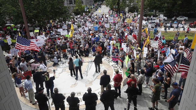 People gather outside the North Carolina Legislative Building to protest the current stay-at-home orders issued by Gov. Roy Cooper amid the outbreak of COVID-19 in Raleigh, N.C., Tuesday, April 28, 2020. (AP Photo/Gerry Broome)