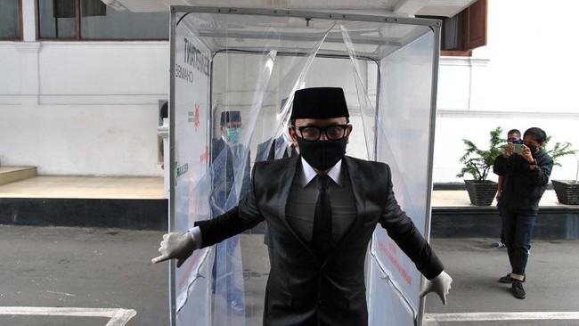 Wali Kota Bogor Bima Arya keluar dari bilik disinfektan saat menuju ruang pelantikan pejabat struktural di lingkungan Pemerintah Kota Bogor di Ruang Paseban Sri Baduga, Balaikota Bogor, Jawa Barat, Selasa (28/4/2020). Wali Kota Bogor Bima Arya dengan menggunakan masker dan sarung tangan kembali bertugas normal dan memimpin jalannya pemerintahan setelah dinyatakan sembuh total dari virus Corona (COVID-19). ANTARA FOTO/Arif Firmansyah/foc.