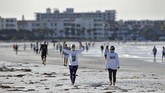 musim panas yang suram FILE - In this April 27, 2020, file photo, two women wearing safety masks stretch as they walk on Siesta beach in Siesta Key, Fla. As the weather warms, some already have begun venturing outside in larger numbers, despite guidance to stay home. Government officials say they aim to manage public health risks in a way that allows for a gradual return to normal, but with the course of the outbreak still unknown, nobody is sure what summer will bring. (AP Photo/Chris O'Meara, File)