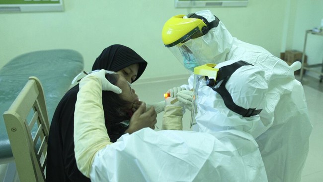 Petugas medis melakukan tes swab kepada salah satu pasien dalam pengawasan (PDP) di Rumah Sakit Umum Kota Tarakan (RSUKT), Kalimantan Utara, Selasa (28/4/2020). Tes swab tersebut dilakukan guna memastikan tertular atau tidaknya angota keluarga yang dinyatakan positif COVID-19. ANTARA FOTO/Fachrurrozi/hp.