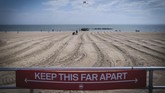 musim panas yang suram FILE - In this April 12, 2020, file photo, a sign on the Coney Island boardwalk reminds people to keep their distance in New York. From Cape Cod to California, festivals are being canceled, businesses in tourist havens are looking at empty reservation books, and people who have been cooped up through a dismal spring are worrying summer will bring just more of the same. (AP Photo/Seth Wenig, File)