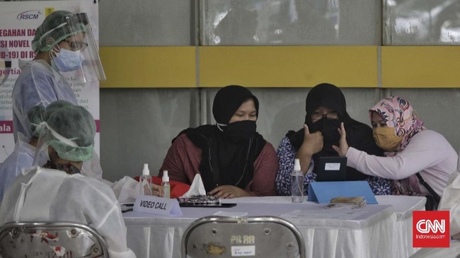 Petugas membantu salah satu kerabat untuk menghubungi pasien melalui layanan panggilan video di Rumah Sakit Umum Pusat Nasional (RSUPN) Dr. Cipto Mangunkusumo, Jakarta, Kamis, 30 April 2020. Pihak rumah sakit menyediakan fasilitas Pojok Sahabat kepada warga yang ingin menghubungi pasien suspect maupun positif terinfeksi virus corona yang tidak memiliki atau tidak mampu mengoperasikan alat komunikasi. CNNIndonesia/Adhi Wicaksono
