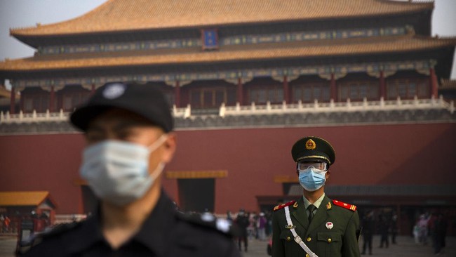 Chinese paramilitary police and security officers wear face masks to protect against the spread of the new coronavirus as they stand guard outside an entrance to the Forbidden City in Beijing, Friday, May 1, 2020. The Forbidden City reopened beginning on Friday, China's May Day holiday, to limited visitors after being closed to the public for more than three months during the coronavirus outbreak. (AP Photo/Mark Schiefelbein)