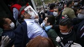 Peringatan May Day saat Pandemi Covid-19 Demonstrators, some wearing face masks for protection against coronavirus, are pushed into a police bus after they were arrested by Turkish police officers during May Day protests in Istanbul, Friday, May 1, 2020. Police in Istanbul detained several demonstrators who tried to march toward Istanbul's symbolic Taksim Square in defiance of the ban by the government, citing security concerns and the coronavirus lockdown. (AP Photo/Emrah Gurel)