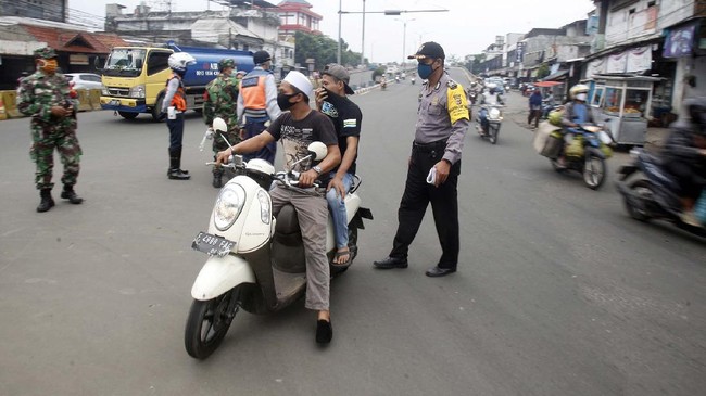 Petugas gabungan menindak pengendara motor yang tidak memakai masker di titik pemeriksaan penerapan Pembatasan Sosial Berskala Besar (PSBB), Cibinong, Bogor, Jawa Barat, Jumat (1/5/2020). Pemerintah melakukan berbagai upaya guna mencegah penyebaran COVID-19 salah satunya menggunakan masker, namun imbauan tersebut masih saja diabaikan karena rendahnya kesadaran masyarakat. ANTARA FOTO/Yulius Satria Wijaya/wsj.