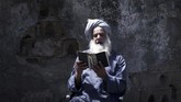 Nyalang Edisi 2 Mei 2020 A Palestinian man reads the Koran during the holy month of Ramadan in Gaza City during the COVID-19 coronavirus pandemic on April 28, 2020. (Photo by MOHAMMED ABED / AFP)
