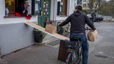 Gaya Hidup Bersepeda di Tengah Pandemi FILE - In this April 3, 2020, file photo, a man on a bike picks up food to go in front of the apple cider restaurant 'Zum Lahmen Esel' in Frankfurt, Germany. Cycling activists from Germany to Peru are trying to use the moment to get more bike lanes, or widen existing ones, even if it is just a temporary measure to make space for commuters on two wheels. (AP Photo/Michael Probst, File)