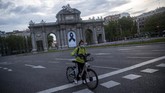 Gaya Hidup Bersepeda di Tengah Pandemi In this photo taken on Saturday, April 25, 2020, a woman rides Madrid's electric bike hire service BiciMAD in front of a Puerta de Alcala square with a black ribbon for the victims of COVID-19 as the lockdown to combat the spread of coronavirus continues in downtown Madrid, Spain. As countries seek to get economies back on track after the outbreak, bicycle use is being encouraged as a way to avoid any unsafe crowding on trains and buses. (AP Photo/Manu Fernandez)