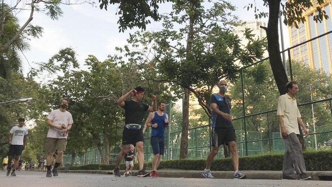 Joggers return to a popular park as the lockdown was lifted, Sunday, May 3, 2020, in Bangkok, Thailand.  Residents of Thailand's capital enjoyed the city's parks, booked haircuts and stocked up on beer and other alcoholic drinks Sunday as they enjoyed their first day of eased restrictions that were imposed weeks ago to combat the spread of the coronavirus. (AP Photo/Tassanee Vejpongsa)