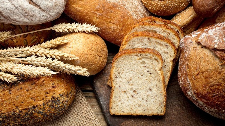 heap of various bread on wooden background