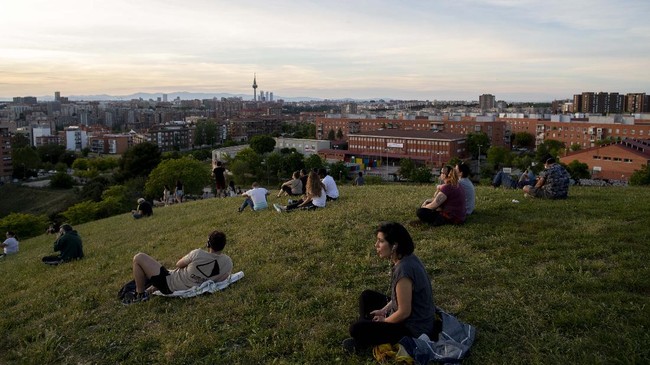 People sit in the Cerro del Tio Pio park in Madrid, Spain, Spain, Sunday, May 3, 2020. On Saturday, Spaniards were able to go outdoors to do exercise for the first time in seven weeks since the lockdown began to battle the coronavirus outbreak. (AP Photo/Manu Fernandez)