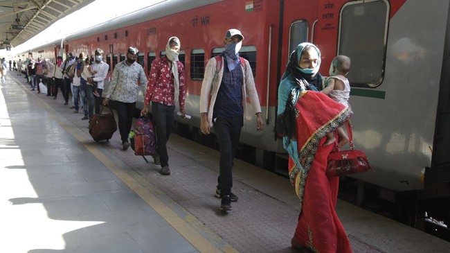 Migrant workers walk to board a special train to return to Agra in Uttar Pradesh state, during a nationwide lockdown to curb the spread of new coronavirus, at a railway station in Ahmedabad, in the western Indian state of Gujarat, Saturday, May 2, 2020. India on Friday ran the first train service for thousands of migrant workers desperate to return home since it imposed a nationwide lockdown to control the spread of the coronavirus. Several states, including Rajasthan, Jharkhand, Bihar, Kerala, Maharashtra, Uttar Pradesh, Punjab and Telangana have demanded special trains for returning workers because they couldn't arrange enough buses. Around 1 million migrant workers from Uttar Pradesh are still stranded in other Indian states, state government spokesman, Awanish Awasthi said. (AP Photo/Ajit Solanki)
