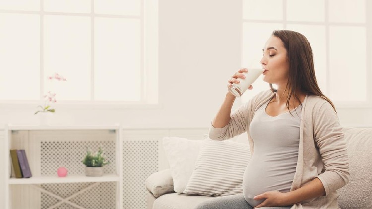 susu ibu hamil Pregnant woman drinking glass of milk copy space. Young expectant lady enjoying healthy drink. Healthcare, nutrition, vitamins, pregnancy concept