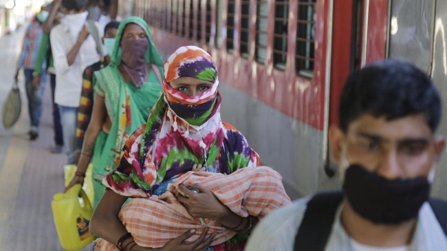 Migrant workers stand to board a special train to return to Agra in Uttar Pradesh state, during a nationwide lockdown to curb the spread of new coronavirus, at a railway station in Ahmedabad, in the western Indian state of Gujarat, Saturday, May 2, 2020. India on Friday ran the first train service for thousands of migrant workers desperate to return home since it imposed a nationwide lockdown to control the spread of the coronavirus. Several states, including Rajasthan, Jharkhand, Bihar, Kerala, Maharashtra, Uttar Pradesh, Punjab and Telangana have demanded special trains for returning workers because they couldn't arrange enough buses. Around 1 million migrant workers from Uttar Pradesh are still stranded in other Indian states, state government spokesman, Awanish Awasthi said. (AP Photo/Ajit Solanki)