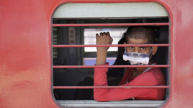 A migrant workers sits inside a special train to return to Agra in Uttar Pradesh state, during a nationwide lockdown to curb the spread of new coronavirus, at a railway station in Ahmedabad, in the western Indian state of Gujarat, Saturday, May 2, 2020. India on Friday ran the first train service for thousands of migrant workers desperate to return home since it imposed a nationwide lockdown to control the spread of the coronavirus. Several states, including Rajasthan, Jharkhand, Bihar, Kerala, Maharashtra, Uttar Pradesh, Punjab and Telangana have demanded special trains for returning workers because they couldn't arrange enough buses. Around 1 million migrant workers from Uttar Pradesh are still stranded in other Indian states, state government spokesman, Awanish Awasthi said. (AP Photo/Ajit Solanki)