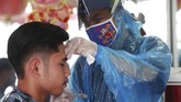 Jasa Pangkas Rambut Gunakan APD A barber wearing a face mask to protect against the new coronavirus shaves a customer at a barbershop in Jakarta, Indonesia, Friday, May 1, 2020. (AP Photo/Achmad Ibrahim)
