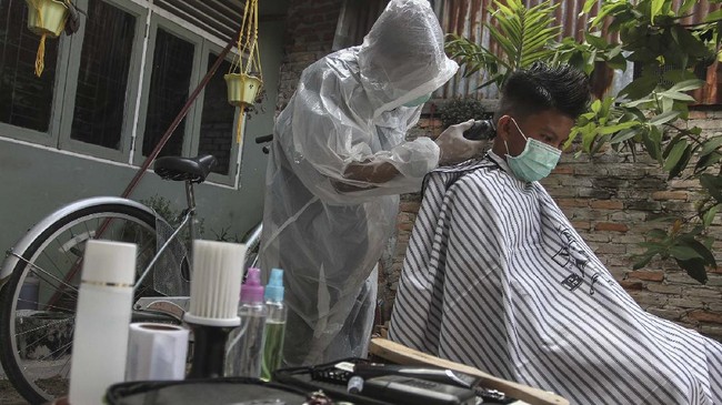 FOTO: Menengok Jasa Pangkas Rambut dengan APD Lengkap