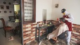 Jasa Pangkas Rambut Gunakan APD Seorang tukang cukur menggunakan Alat Pelindung Diri (APD) saat memotong rambut di halaman rumah pelanggan di Kelapa Dua, Depok, Jawa Barat, Senin (27/4/2020). Penerapan Pembatasan Sosial Berskala Besar (PSBB) Kota Depok membuat Pelaku usaha cukur rambut tersebut menerima jasa panggilan cukur ke rumah dengan menggunakan APD sebagai upaya pencegahan virus corona (COVID-19). ANTARA FOTO/Asprilla Dwi Adha/hp.