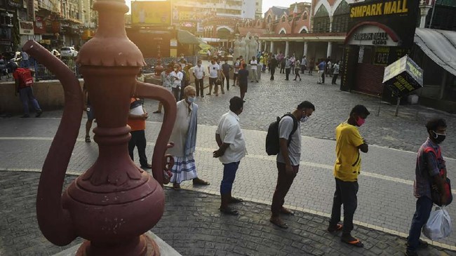 People wait in a queue outside a liquor shop to buy alcohol after the government eased a nationwide lockdown imposed as a preventive measure against the COVID-19 coronavirus, in Kolkata on  May 4 2020. (Photo by Dibyangshu SARKAR / AFP)