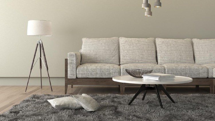 Karpet Rumah Minimalis Designer table on brown carpet in front of grey sofa with decorative pillows against tubes in living room