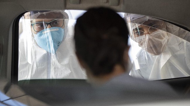 In this Monday, March 30, 2020 photo, medical personnel interview commuters, checking to see if they have symptoms of the novel cornavirus, in Guarulhos, on the outskirts of Sao Paulo, Brazil. (AP Photo/Andre Penner)