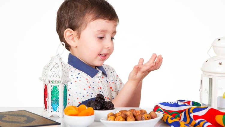 1143091298 Young Muslim boy praying to Allah while waiting for iftar( breakfast ) in Ramadan