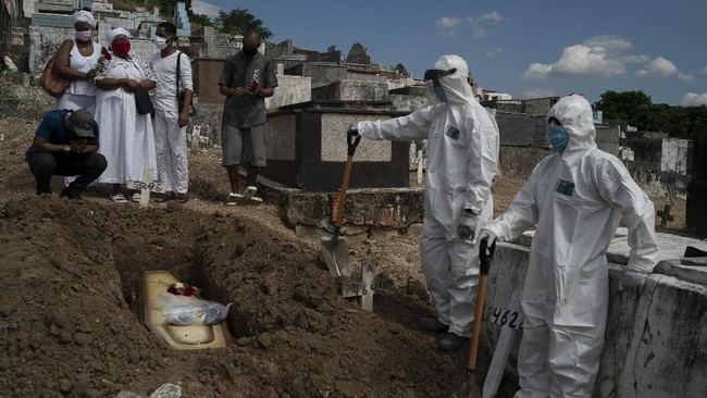 In this Tuesday, April 28, 2020 photo, Taina dos Santos, third from left, attends the burial of her mother Ana Maria, a 56-year-old nursing assistant who died from the new coronavirus, in Rio de Janeiro, Brazil. (AP Photo/Leo Correa)