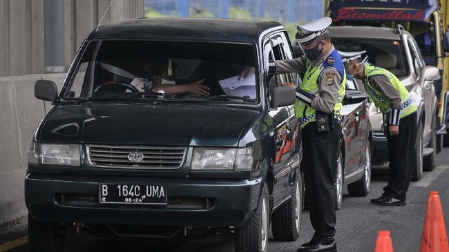 Petugas Kepolisian mengecek identitas mobil  pribadi yang melintasi tol Jakarta-Cikampek di Cikarang Barat, Kabupaten Bekasi, Jawa Barat, Sabtu (9/5/2020). Direktorat Lalu Lintas (Dirlantas) Polda Metro Jaya akan menindak tegas kendaraan yang berupaya membawa penumpang keluar Jabodetabek dengan Undang- Undang nomor 22 tahun 2009 tentang Lalu Lintas dan Angkutan Jalan (LLAJ) saat penerapan larangan mudik. ANTARA FOTO/ Fakhri Hermansyah/hp.