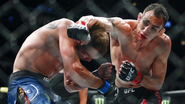 FILE - In this June 8, 2019, file photo, Tony Ferguson, right, punches Donald Cerrone, left, during their lightweight mixed martial arts bout at UFC 238 in Chicago. Ferguson and Justin Gaethje will headline the mixed martial arts card at UFC 249 behind closed doors at Veterans Memorial Arena in Jacksonville, Fla., Saturday, May 9, 2020. UFC 249 will serve as the first major sporting event to take place since the coronavirus pandemic shut down much of the country nearly two months ago. (AP Photo/Kamil Krzaczynski, File)