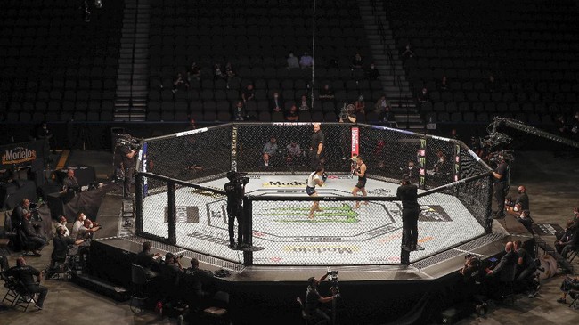 Michelle Waterson, center left, and Carla Esparza battle without spectators during a UFC 249 mixed martial arts bout, Saturday, May 9, 2020, in Jacksonville, Fla. (AP Photo/John Raoux)