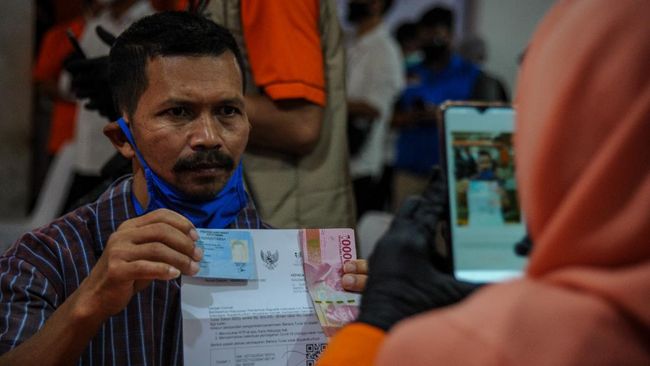 PENYALURAN BANTUAN SOSIAL TUNAI Petugas memotret Keluarga Penerima Manfaat (KPM) yang telah menerima Bantuan Sosial Tunai (BST) di Kantor Pos Cimahi, Jawa Barat, Minggu (10/5/2020). Pemerintah melalui Kementerian Sosial menyalurkan dana bantuan sosial tunai senilai Rp600.000 kepada 13.491 Keluarga Penerima Manfaat di Kota Cimahi yang terdampak wabah COVID-19. ANTARA FOTO/Raisan Al Farisi/foc.