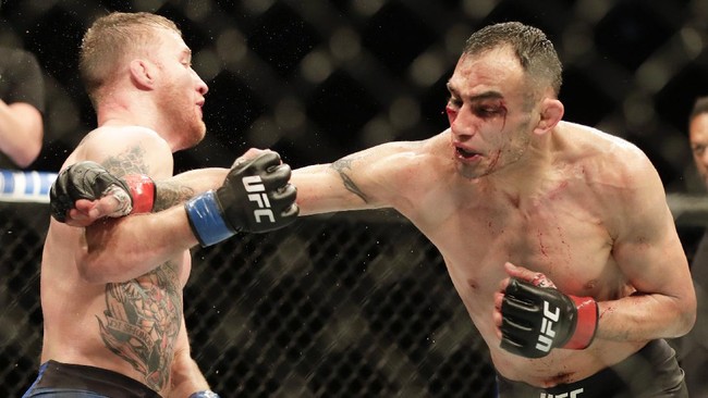 Justin Gaethje, left, dodges a punch from Tony Ferguson during a UFC 249 mixed martial arts bout, late Saturday, May 9, 2020, in Jacksonville, Fla. (AP Photo/John Raoux)