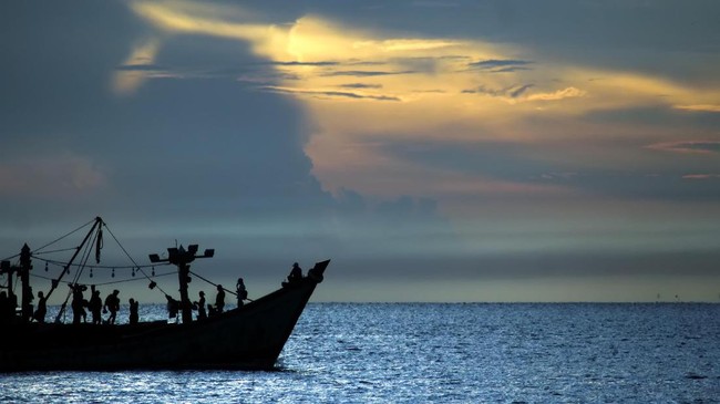 Kapal nelayan melintas dengan latar belakang matahari terbit di perairan Selat Malaka, Lhokseumawe, Aceh, Rabu (8/4/2020). Para nelayan kembali beraktivitas melaut pascagelombang tinggi sebagai dampak fenomena supermoon. ANTARA FOTO/Rahmad/aww.