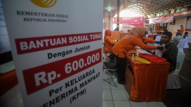 Petugas memberikan Bantuan Sosial Tunai (BST) pada Keluarga Penerima Manfaat (KPM) di Kantor Pos Cimahi, Jawa Barat, Minggu (10/5/2020). Pemerintah melalui Kementerian Sosial menyalurkan dana bantuan sosial tunai senilai Rp600.000 kepada 13.491 Keluarga Penerima Manfaat di Kota Cimahi yang terdampak wabah COVID-19. ANTARA FOTO/Raisan Al Farisi/foc.
