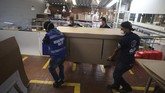 Tempat Tidur Sekaligus Peti Mati Workers at a company that designs packaging for product displays carry a box containing one of their co-workers to demonstrate how their new design of a cardboard box can serve as both a hospital bed and a coffin, designed for COVID-19 patients, in Bogota, Colombia, Friday, May 8, 2020. Owner Rodolfo Gomez said he plans to donate the first units to Colombia's Amazonas state, and that the company will sell others to small hospitals for 87 dollars. (AP Photo/Fernando Vergara)