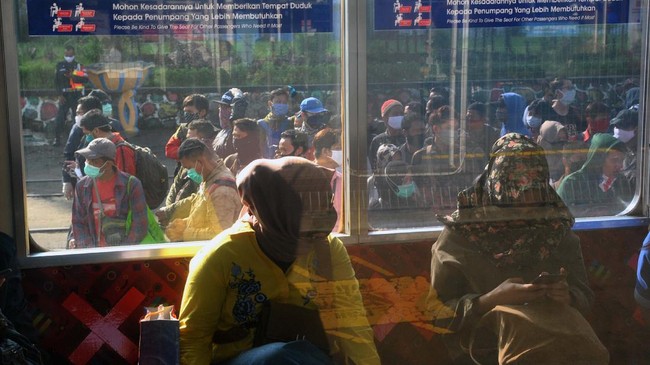 Sejumlah penumpang KRL Commuter Line antre menunggu kedatangan kereta di Stasiun Bogor, Jawa Barat, Senin (13/4/2020). Antrean panjang penumpang KRL Commuter Line di Stasiun Bogor tersebut akibat kebijakan pemeriksaan suhu tubuh dan pembatasan jumlah penumpang di setiap rangkaian kereta sebagai tindakan pencegahan penyebaran wabah pandemi virus Corona (COVID-19). ANTARA FOTO/Arif Firmansyah/hp.