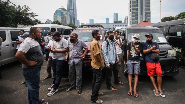 Pengemudi travel dan penumpangnya beristirahat usai terjaring dalam operasi penyekatan di Polda Metro Jaya, Jakarta, Senin (11/5/2020). Dalam kurun waktu tiga hari operasi penyekatan, yakni mulai 8-10 Mei, Polda Metro Jaya mengamankan 202 kendaraan travel gelap yang mencoba mengangkut pemudik ke luar dari Jakarta. ANTARA FOTO/Rivan Awal Lingga/wsj.