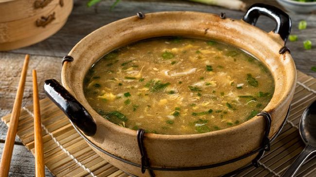 A bowl of delicious egg drop soup with green onion garnish.