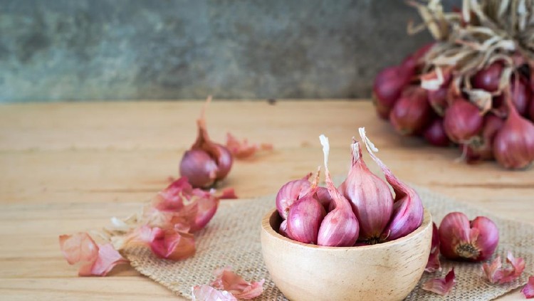 shallots in bowl on old wooden table with old wallpaper and shallots bunch background